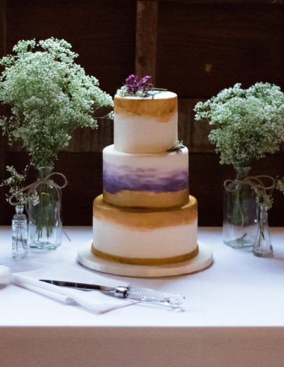 gold and purple watercolor on fondant wedding cake