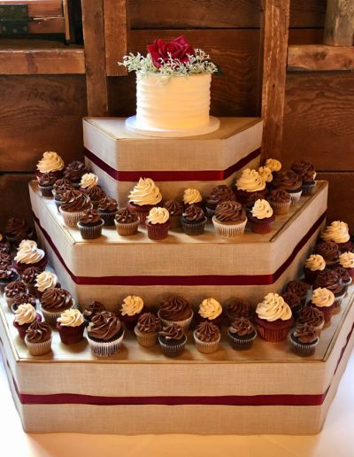 small cutting cake on 3 tiers of mini and normal sized cupcakes