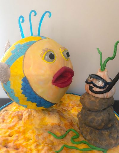 cake for garlic festival featuring miss garlic in a snorkel and a large fish