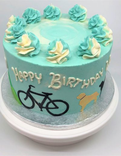 birthday cake with sides of bike, dogs, mountains