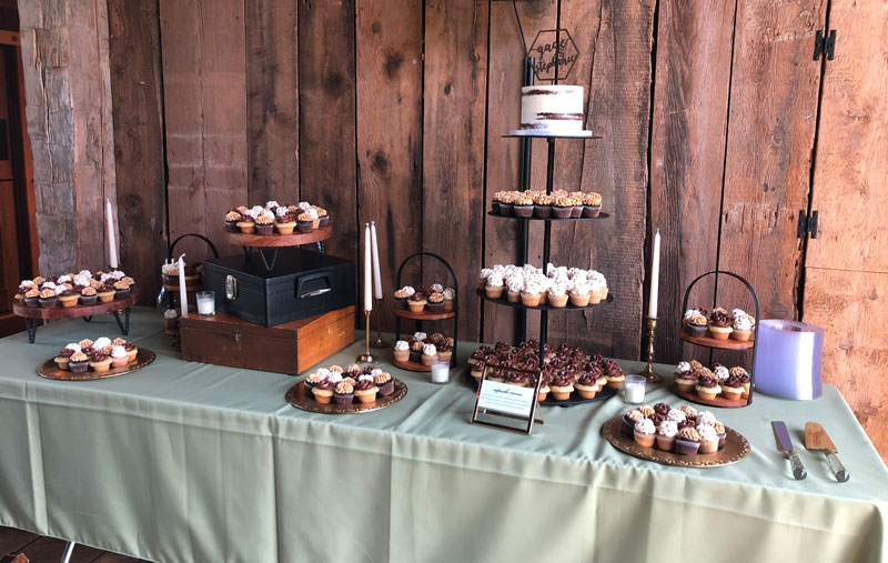 cupcake setup with cutting cake and many types of stands and platters