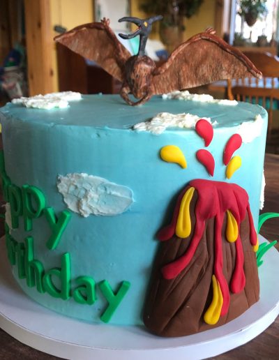 birthday cake with volcano with lava and pteradactyl on top
