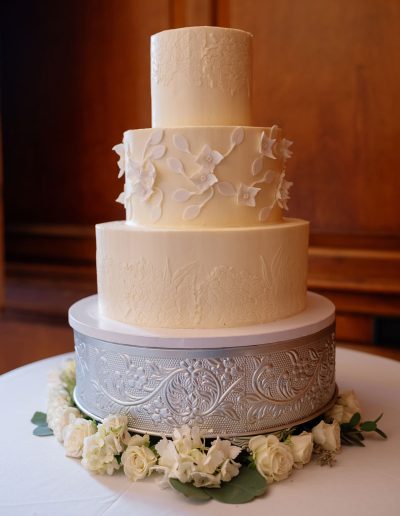 3-tier white wedding cake with hydrangea stencil on top and bottom tier and gumpaste hydrangeas in the middle