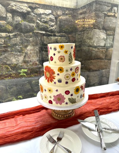3-tier wedding cake with dried flowers on the outside of all tiers