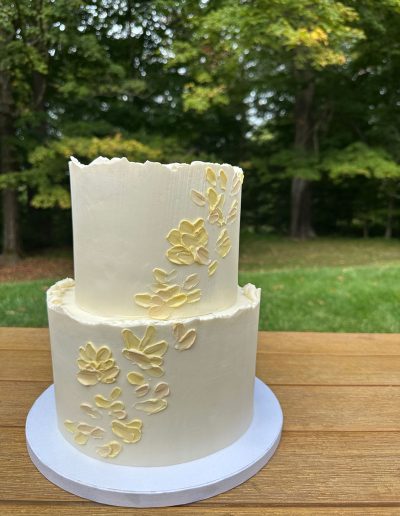 small 2-tier wedding cake with yellow palette knife shapes